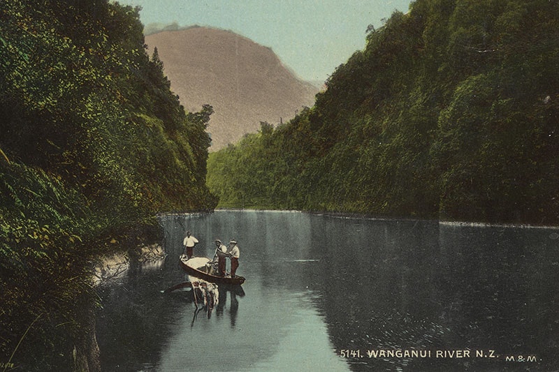 View of Whanganui River with steep sides offering a cavernous view, with three men on a kayak
