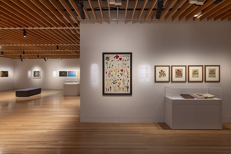 Exhibition view showing a large painting on the wall in the centre, and four smaller paintings beside it on the right