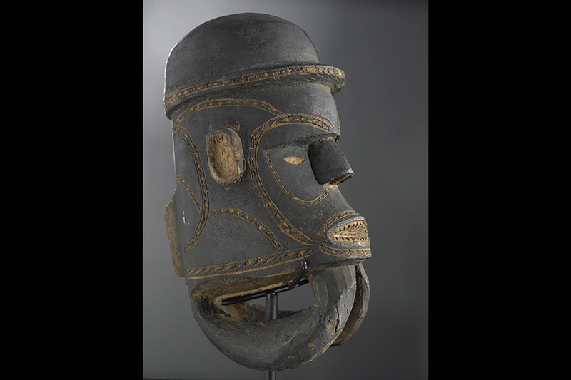 A carved wooden head with inlaid shell.