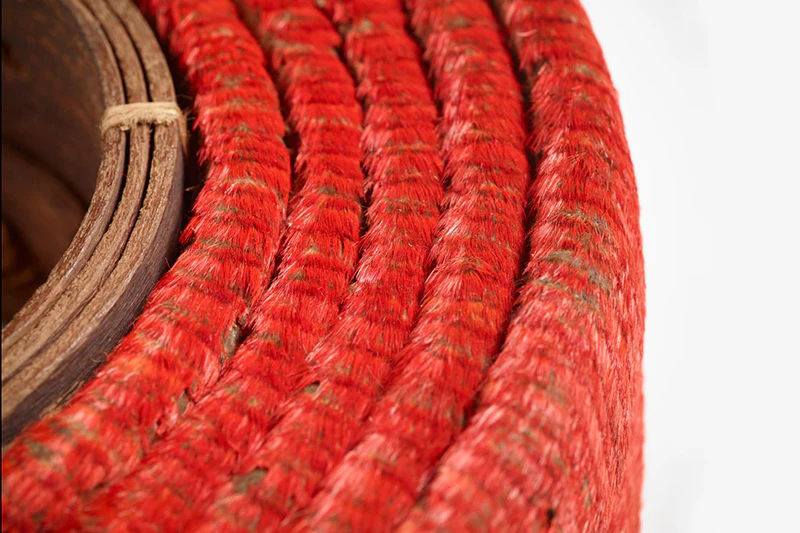 A coiled belt made of hundreds of small red feathers and leather in the middle.