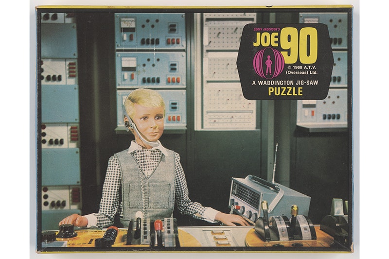 A photo of the top of a jigsaw puzzle box with an image from the TV series Joe 90 on it.