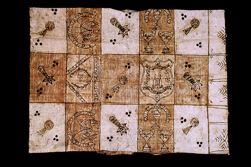 A brown and cream tapa cloth with patterns painted on it.