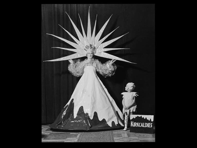 A woman and child on a stage. The woman is dressed as a mountain with a star for a headdress.