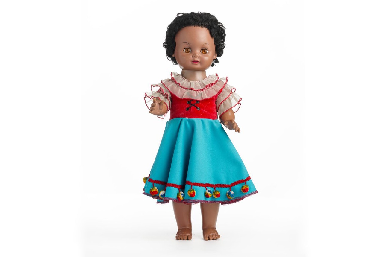 A brown doll – it is a girl in a dress and top. She has black curly hair.