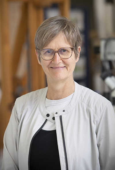 A head and shoulders photo of a woman smiling at the camera.
