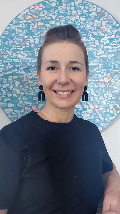Head and shoulders photo of a woman smiling at the camera.