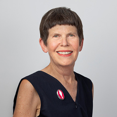 Head and shoulders of a woman with a short-sleeved top on and short hair.
