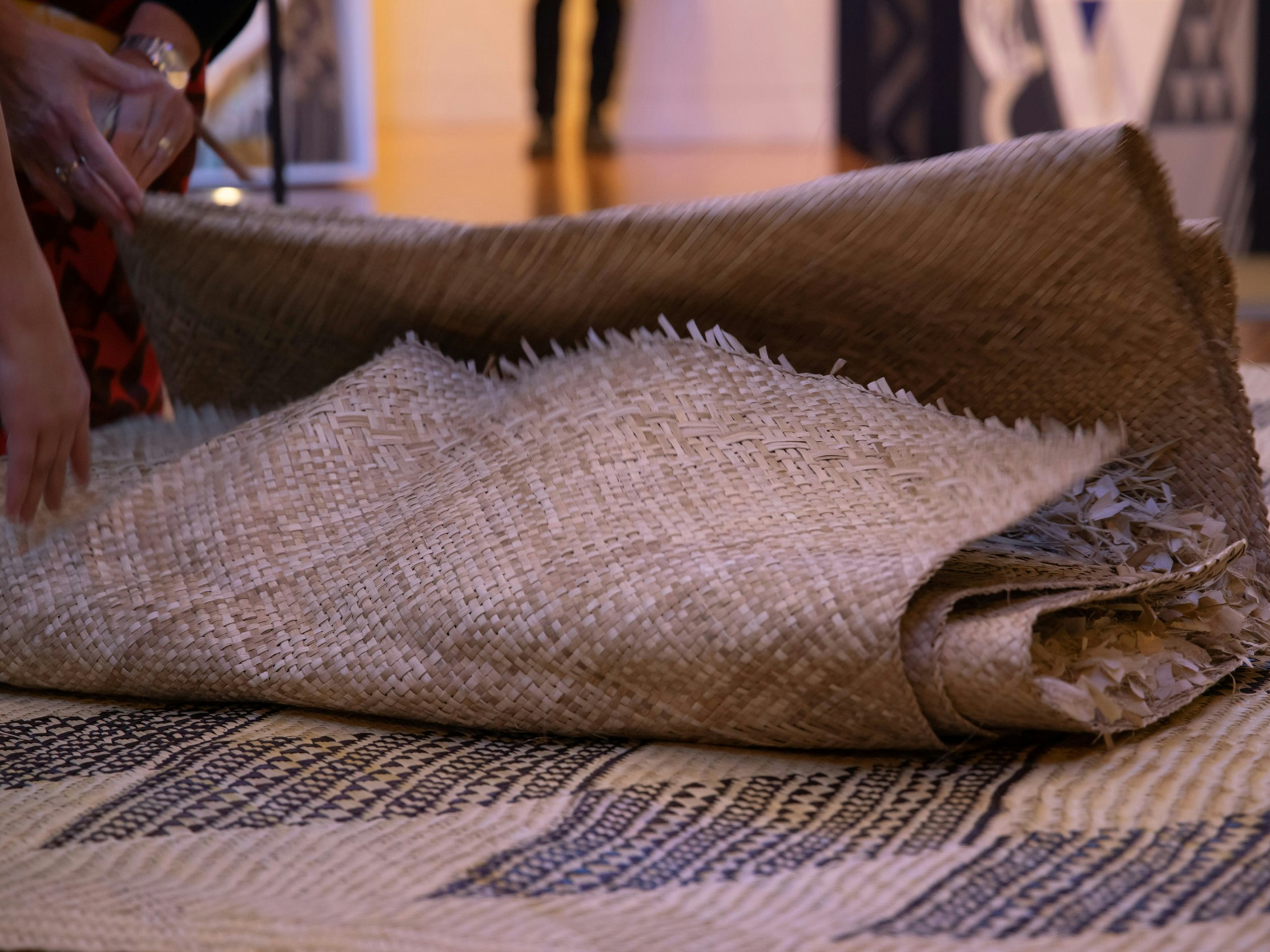 Photo from Rotuman language week at Te Papa, 2021, by Jo Moore. Te Papa (196358) A woven mat lies on the ground on top of another woven mat.