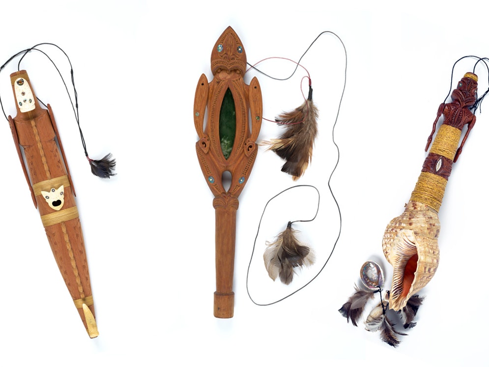 James Webster, Karetao. Te Papa ME024183, ME024214, and ME024209 Three carved wooden marionettes with cords and feathers attached on a white background.