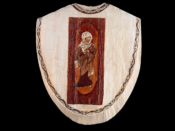 Chasuble, Mata'itini Tu'akoi; decorative artist; 1978; Tongatapu, Fatima Cheeseman; decorative artist; 1978; Tongatapu, 'Etita Tausinga; decorative artist; 1978; Tongatapu. Gift of the Society of Mary, 2002. Te Papa (FE011715) A priest vestment made of tapa with an illustration of Mary on the front.