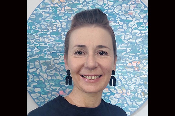 Head and shoulders of a woman smiling at the camera.