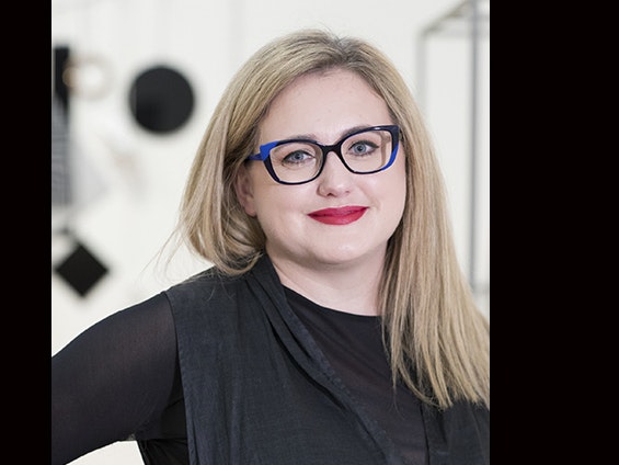 Sarah Farrah. Photo by Kate Whitley. Te Papa A woman with long blond hair and glasses is smiling at the camera.