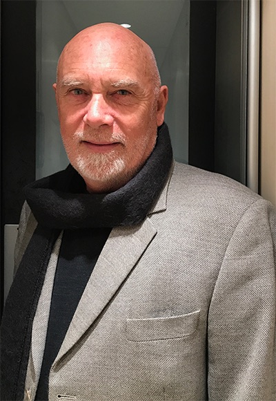 A man with a goatee and no hair is looking at the camera.
