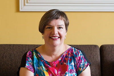 Head and shoulders of a woman with short hair smiling at the camera.