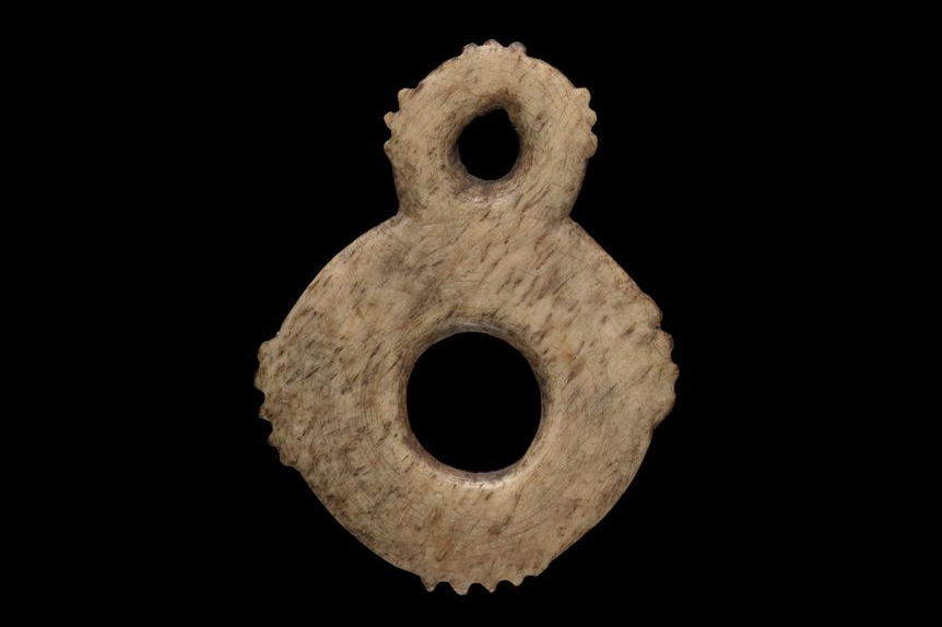 A bone ring with another smaller ring attached at the top.