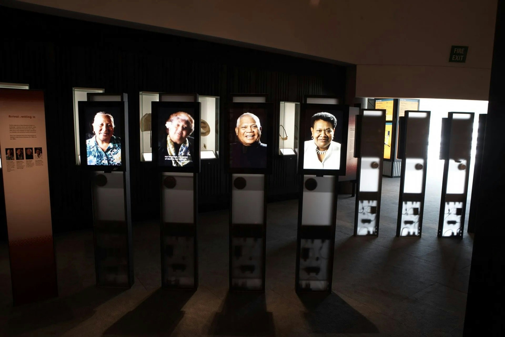 A room with four screens in it. Each screen has a photo of a person looking out.