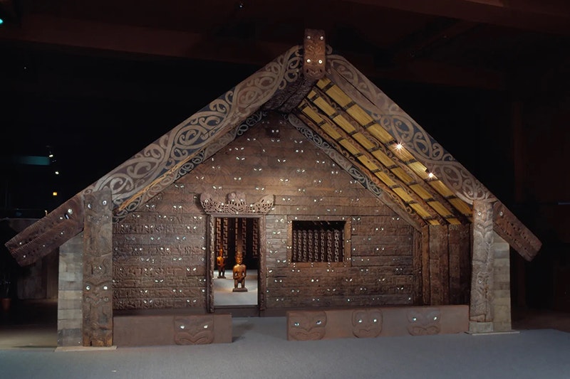 A carved building inside a museum space