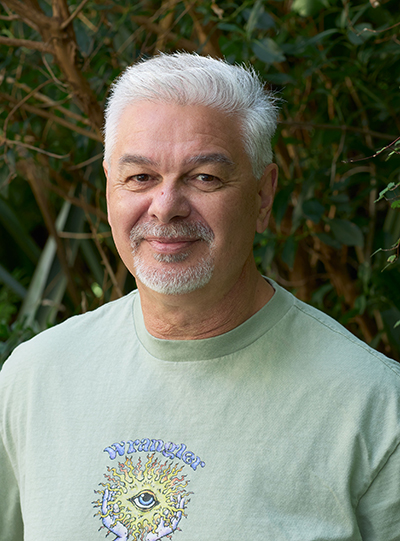 Head and shoulders of a man with white hair and a goatee beard.