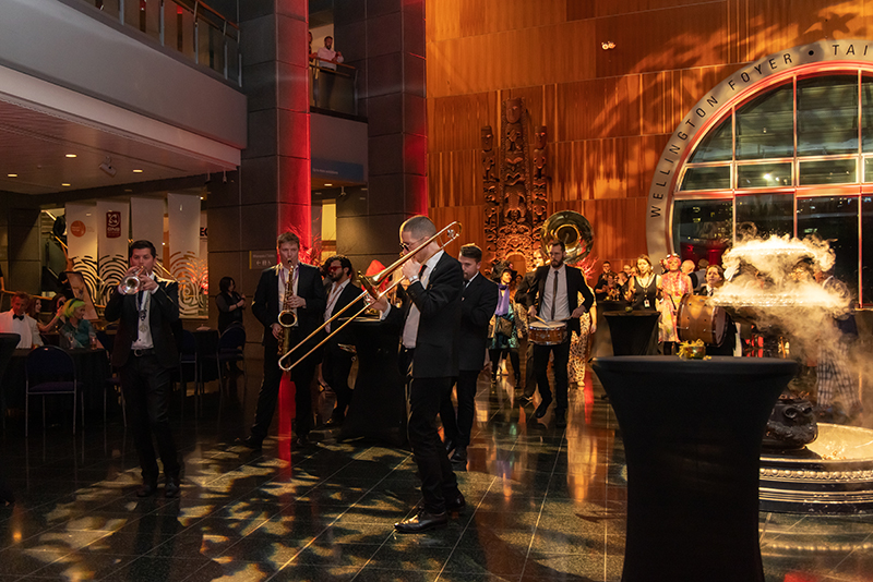 People playing brass instruments are walking through part of the museum.
