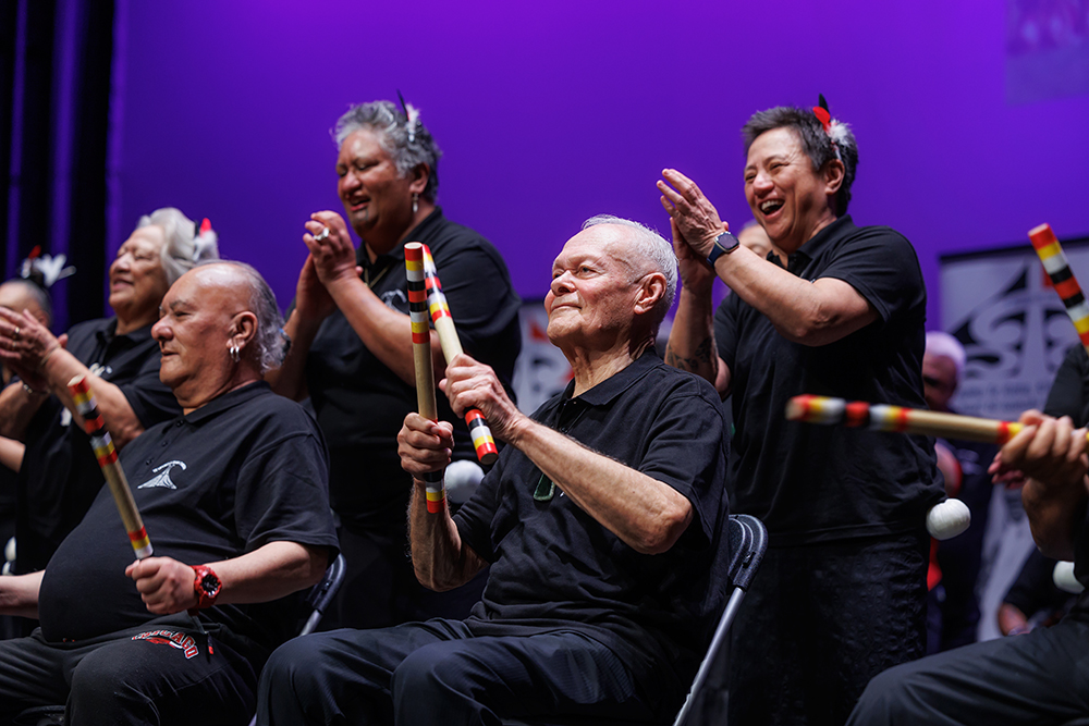 Men and women singing and performing on a stage.