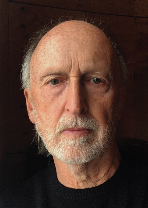 Close-up view of man with grey hair and blue eyes wearing a black shirt