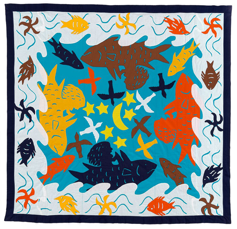 A patchwork quilt with stylised fish, stars, moon, waves, and seaweed images.