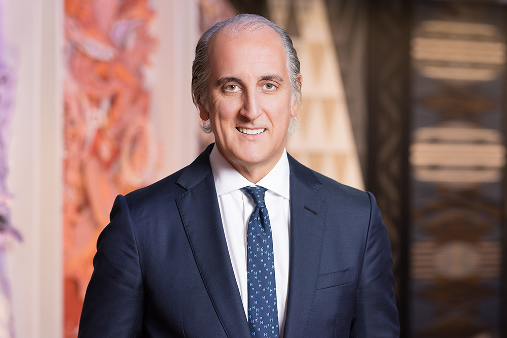 Head and shoulders photo of a man in a blue suit and tie.