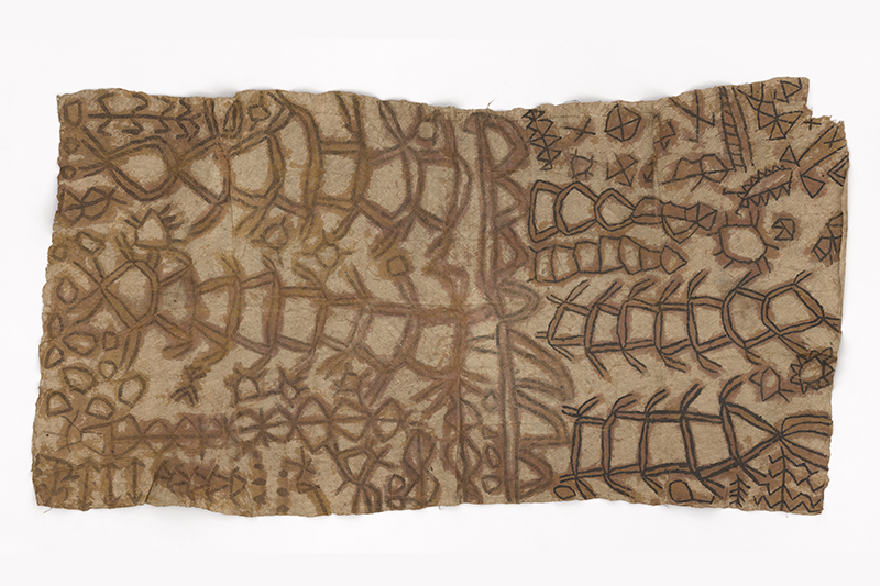 A large piece of bark cloth with patterns drawn on it in a darker dye.