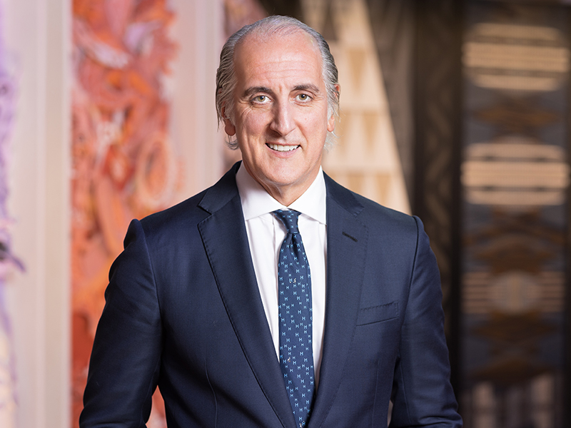 Head and shoulders photo of a man in a blue suit and tie.