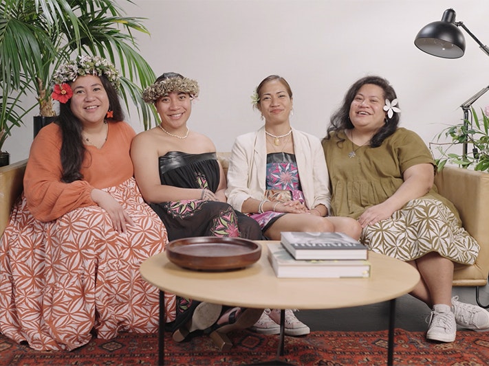 Still from Filo-Masoe sisters for Not Your Dusky Maiden Four women sitting on a sofa smiling at the camera.