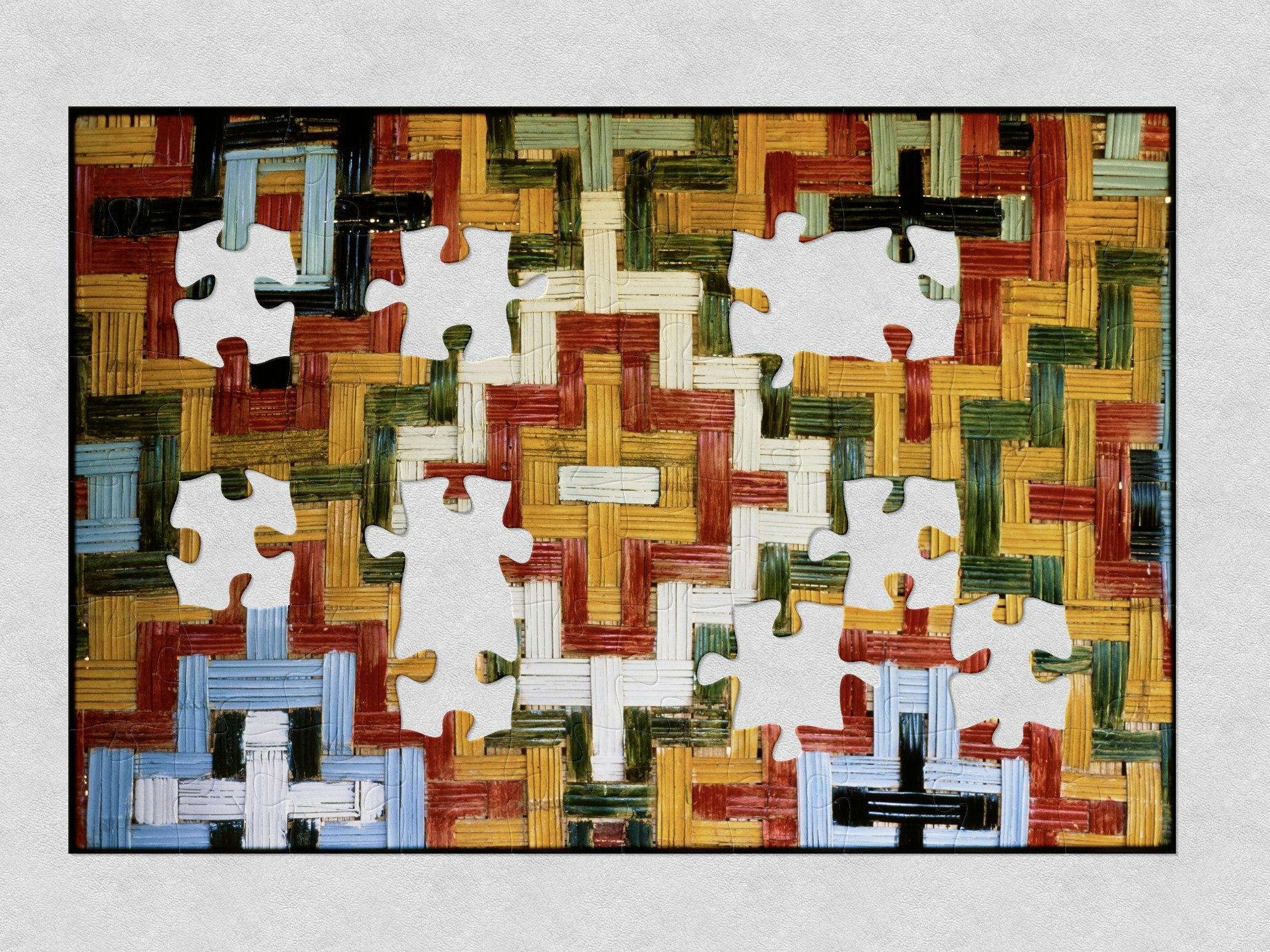 Glenn Jowitt, Painted bamboo wall, Vanuatu, 2004. Gift of Glenn Jowitt Estate, 2015. Te Papa (E.007662) A close photo of a woven wall with the weaving painted in yellow, red, greem, black, light blue, and white, in a step diamond pattern with jigsaw shaped pieces missing.