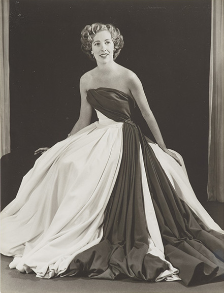 A black and white photo of a woman in a long dress