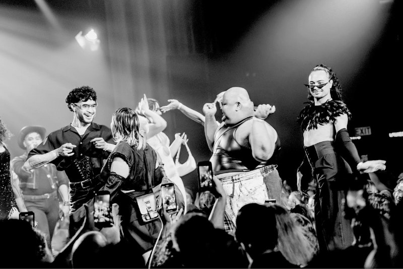 A black and white photo of people dancing on a stage.