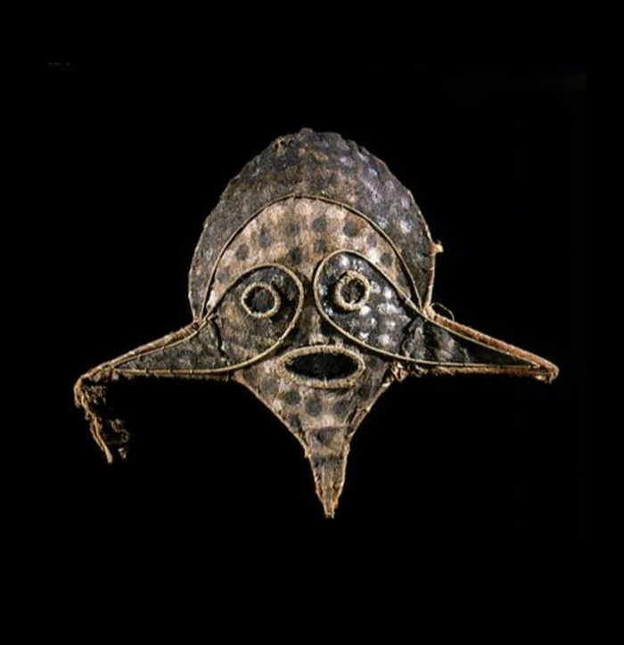 A mask with eyes and a mouth in a round shape with winged tips coming off each side.