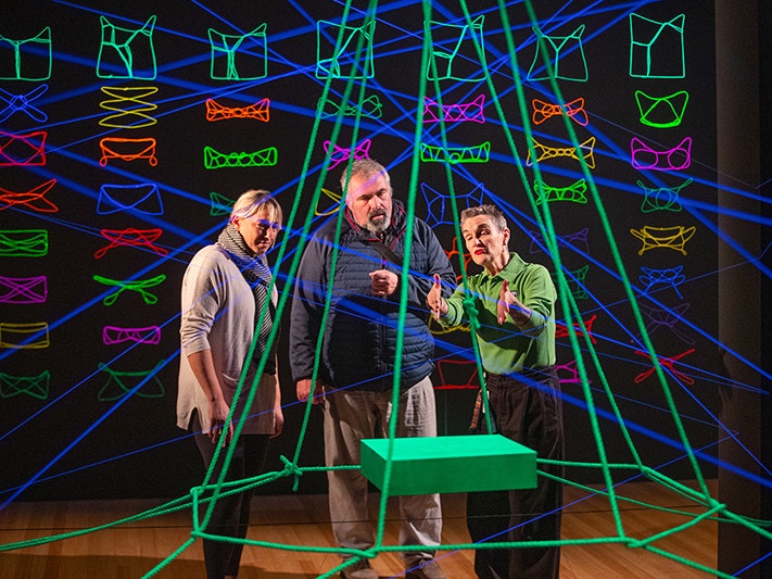 Te Papa hosts, 2025. Photo by Jeff McEwan. Te Papa (271951) A person in a green shirt is describing an artwork to two other people.