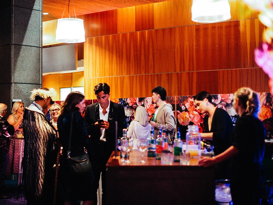 Vivienne Westwood & Jewellery launch event, 2025. Photo by Te Papa (256762) A lot of people standing in a space where there are two people serving drinks.