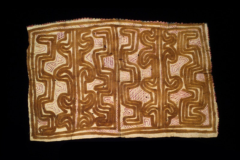 A tapa cloth with bold line designs on a black background.