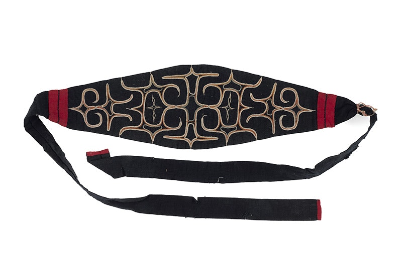 A red, black and gold headband with a wide middle and thin straps.
