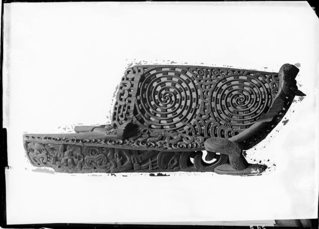 A black and white photo of a Māori carving on a white background.