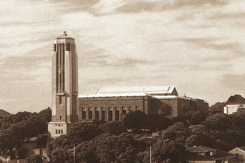 A sepia-toned photograph of a large building and a tall bell tower.