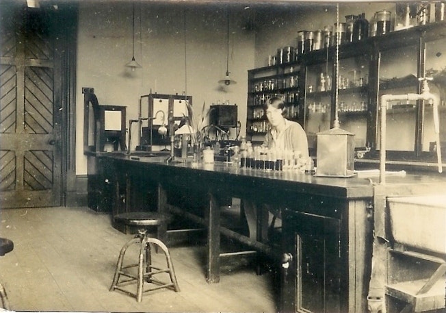 An old photo of a woman in a laboratory in a museum.