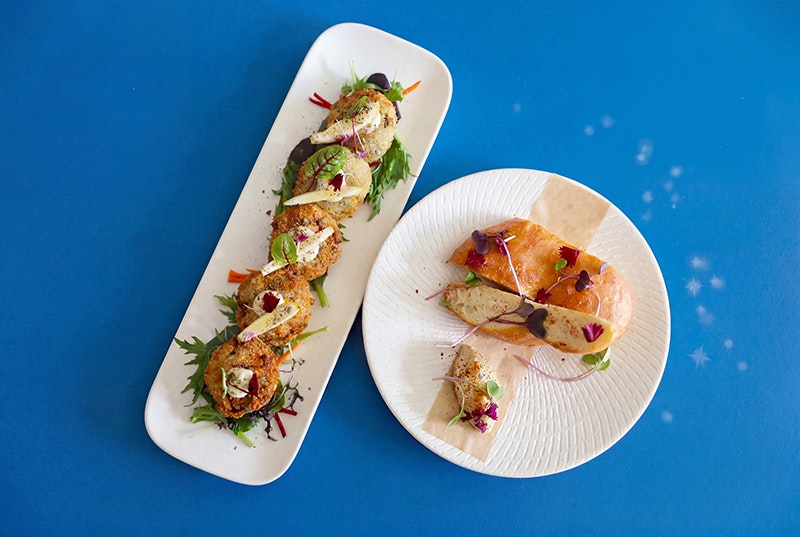 A top-down view of two white plates of food on a blue background.