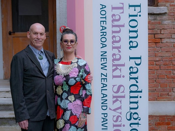 Neil and Fiona Pardington at Venice Biennale. Photography by Waha Creative Two people standing outside a brick building and looking at the camera.