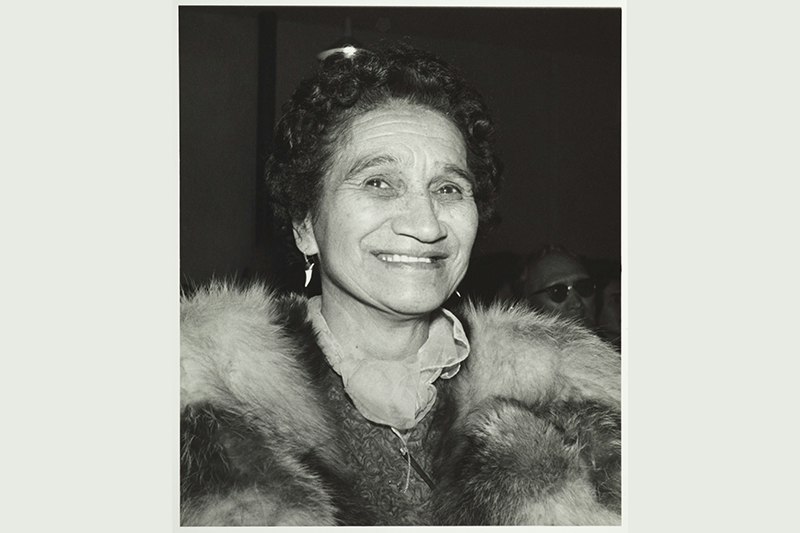 A head and shoulders photograph of a woman wearing a fox stole and smiling.