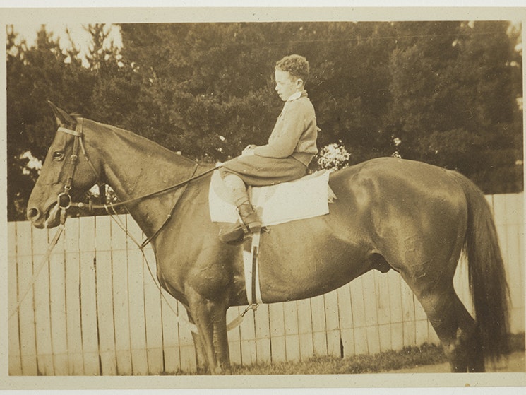 Phar Lap and rider, 1926–28, Upper Hutt. Photo: Dr Martin Tweed. Gift of Philippa Corkill, 1999 (Te Papa O.041341). A sepia photo of a child is sitting on top of a horse.