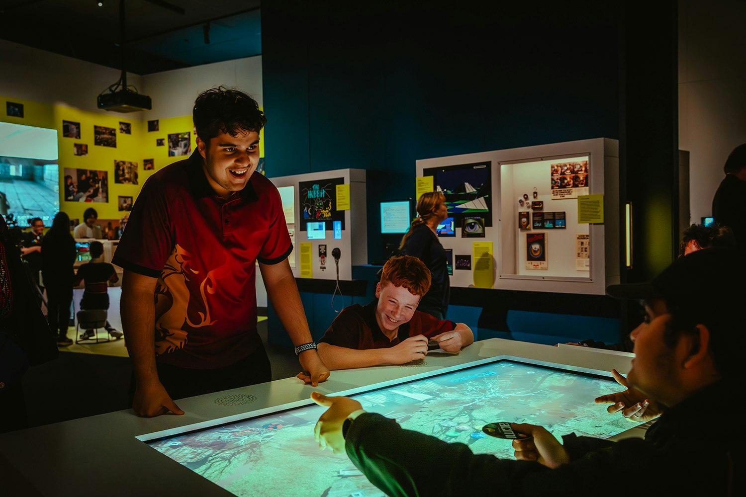 Several teenagers are playing a large video game and laughing at each other.