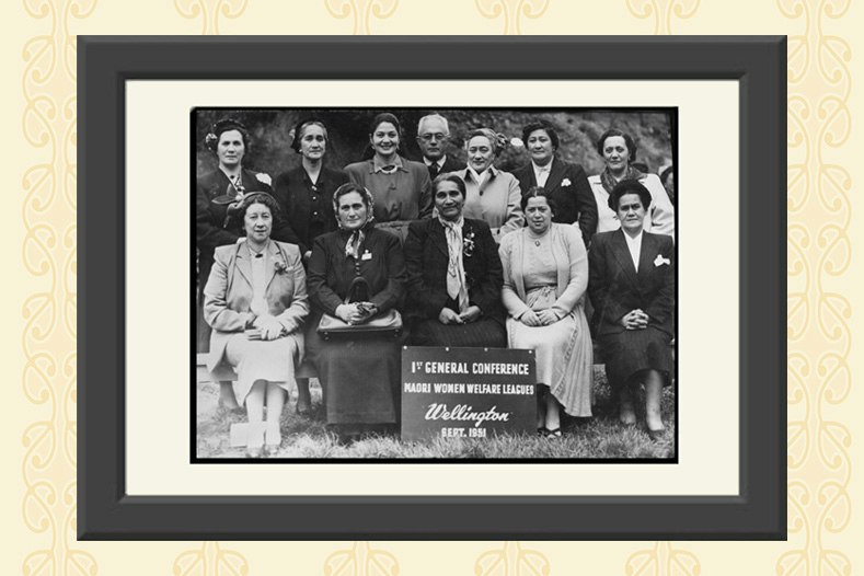 A black and white framed photo with women gathered for a formal photograph with some sitting and some standing behind them.