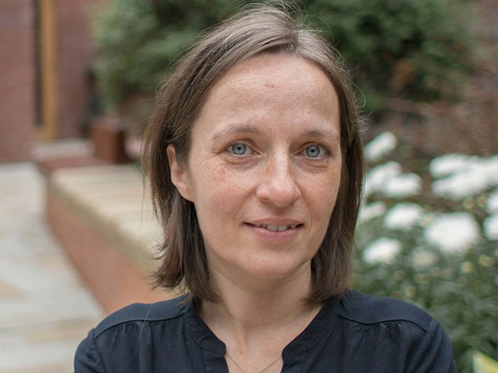 Professor Areti Galani. Photo supplied A head and shoulders photo of a woman with shoulder-length hair and blue eyes. She is standing in a brick courtyard.
